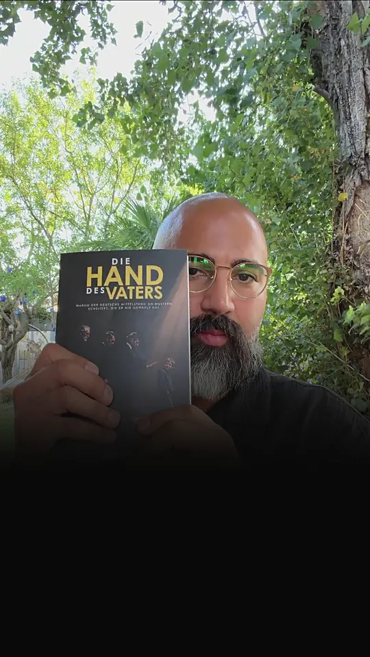Ömer Kaya hält das Buch Die Hand des Vaters in die Kamera